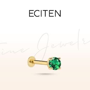 Può includere: Gioiello per il corpo in oro con una pietra preziosa verde. Il gioiello è un orecchino a perno con una piccola pietra preziosa verde rotonda.