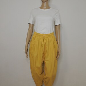 May include: Mustard yellow cropped pants with a drawstring waist and side pockets.