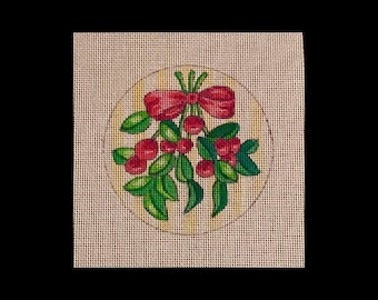 May include: A round needlepoint canvas with a white background and a green and red mistletoe design with a red bow.