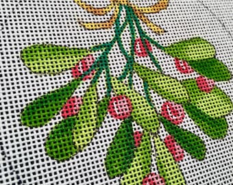 May include: A green and red mistletoe sprig with a yellow bow. The mistletoe is a traditional Christmas decoration.