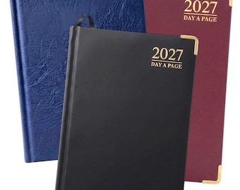 May include: Three 2027 day-a-page planners in blue, black, and burgundy. Each planner features a textured or smooth cover, gold-colored corner protectors, and the text 2027 DAY A PAGE printed in gold on the front cover of each individual book.
