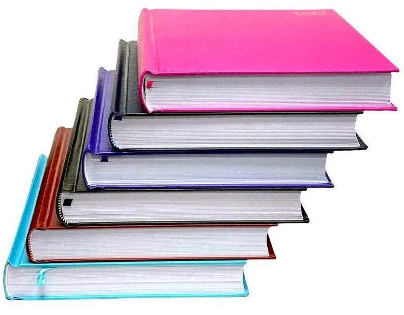 May include: A stack of six books with different colored covers. The top book is pink, the next is black, then dark blue, light blue, brown, and finally a light blue book on the bottom.