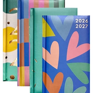 May include: A selection of patterned journals in various colours. Designs include hearts, stripes, and abstract shapes in blue, pink, green, and yellow. The journal on the right has the years 2026 and 2027 printed on it.