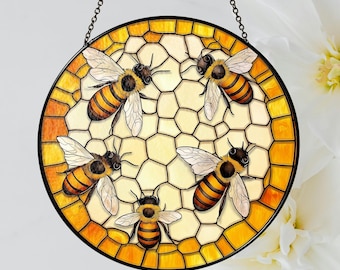 Può includere: Una finestra in vetro colorato appesa con un design circolare di un favo con quattro api in uno schema di colori giallo, marrone e nero.