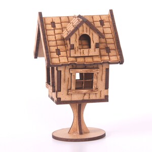 May include: A wooden birdhouse with a shingled roof, two windows, and a stand. The birdhouse is painted in shades of brown.