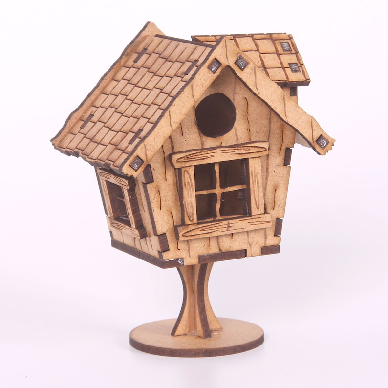 May include: A wooden birdhouse with a shingled roof, a small window, and a round opening. The birdhouse is perched on a wooden stand with a circular base.