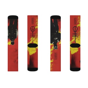 May include: Three pairs of red and yellow socks with a black and white graphic of a person and the text "twenty one pilots" on the side.