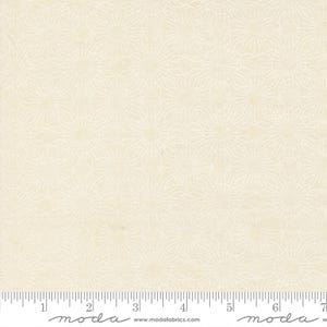 May include: Cream-colored fabric with a repeating floral pattern. The design features delicate, interconnected lines forming stylized flower shapes. A ruler is placed at the bottom, with measurements in inches. The fabric is suitable for quilting and crafting projects.