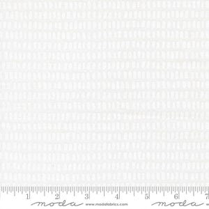 May include: White fabric with a repeating pattern of small, vertical, oval shapes. The pattern is evenly spaced across the fabric. A ruler is at the bottom of the image, with the word "moda" printed on it.