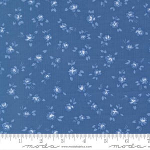 May include: Blue fabric with a floral pattern of small white and light blue roses. The fabric has a textured appearance and is suitable for quilting or other craft projects. The image includes a ruler along the bottom edge.
