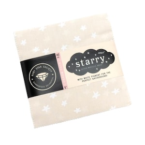 May include: A stack of 5-inch fabric squares with a cream background and white star pattern. The package is labeled "starry" and includes the text "Ruby Star Society". The charm pack contains 42 pieces.