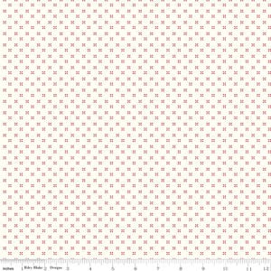 May include: Cream-colored fabric with a repeating pattern of small, red cross-shaped designs. The pattern is evenly spaced across the surface. The fabric is measured in inches along the bottom edge.
