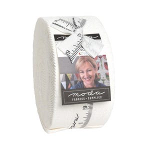 May include: A roll of white fabric with a textured surface. A tag with a woman's image and the words "moda FABRICS + SUPPLIES" is attached. The tag also has a ruler design with the number 19.