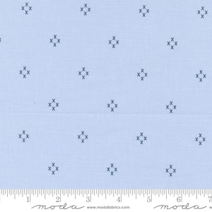 May include: A light blue fabric with a repeating pattern of small, dark blue, stitched squares. The fabric is shown with a ruler for scale.