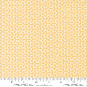 May include: A yellow fabric with a white repeating pattern of small stylized flowers. The fabric is shown with a ruler for scale.