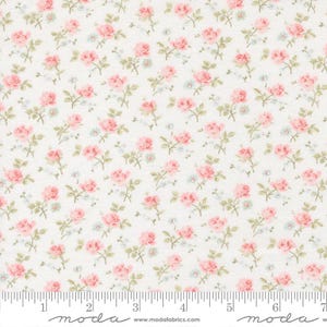 May include: Floral fabric featuring a repeating pattern of pink roses, small blue flowers, and green leaves on a cream background. The fabric has a ruler along the bottom edge with the word "moda" printed on it.