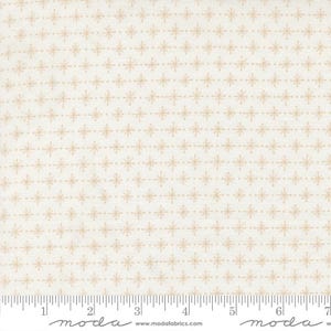 May include: Cream-colored fabric with a repeating pattern of small, tan snowflakes and dotted lines. The fabric has a ruler along the bottom edge, marked in inches. The fabric is from Moda Fabrics.