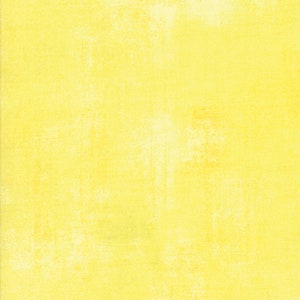 May include: A solid yellow fabric with a subtle textured pattern. The fabric has a slightly distressed look, giving it a vintage feel.