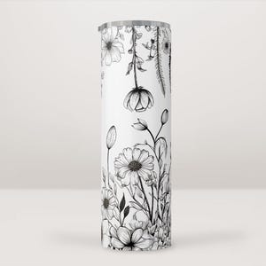 Peut inclure: Un gobelet en acier inoxydable blanc avec un motif floral noir et blanc. Le motif représente différentes fleurs et feuilles.
