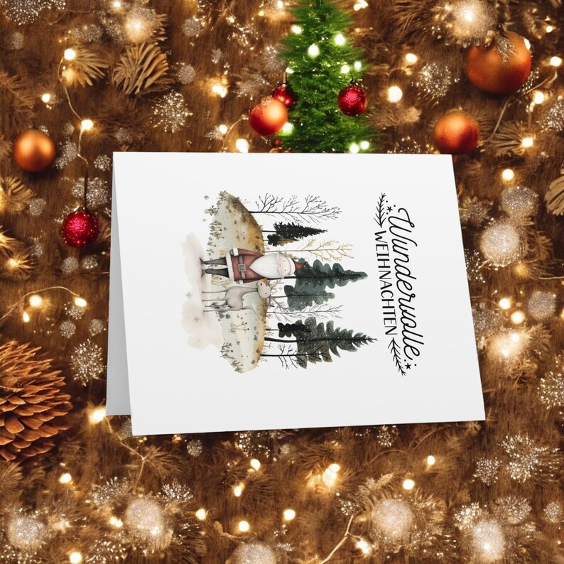 May include: A white card with a watercolor illustration of Santa Claus and a reindeer in a snowy forest. The text "Wundervolle Weihnachten" is written in black cursive on the card.