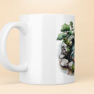 May include: White ceramic mug with a watercolor illustration of a Japanese garden scene. The scene features a small bridge, rocks, trees, and a pond with koi fish.