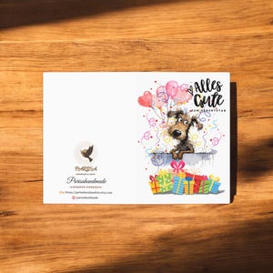 May include: A watercolor illustration of a dog with a surprised expression peeking over a pile of colorful wrapped presents. The dog is surrounded by confetti and balloons, including pink heart-shaped balloons. The text "Alles Gute zum Geburtstag" is written in black lettering at the top of the card.