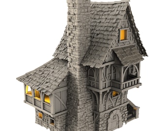 May include: A miniature stone and wood house with a tall chimney and a gabled roof. The house has a small balcony and a door with a window above it. The house is painted in shades of gray and brown.