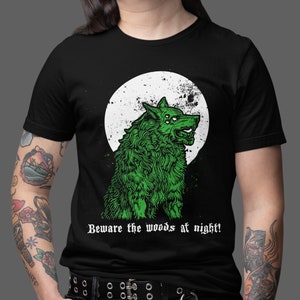 May include: A black t-shirt with a green wolf howling at the moon graphic. The text "Beware the woods at night!" is printed below the wolf.
