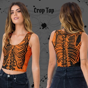 May include: Orange crop top with a black skeleton print. The top is sleeveless and has a scoop neck.