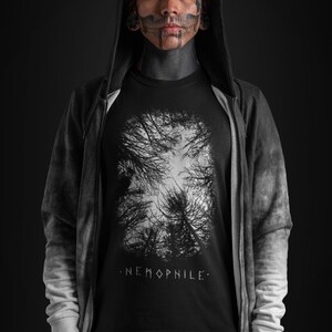 May include: A black hooded sweatshirt with a white graphic print of a forest on the front. The graphic print includes the text ".NEMOPHILE."