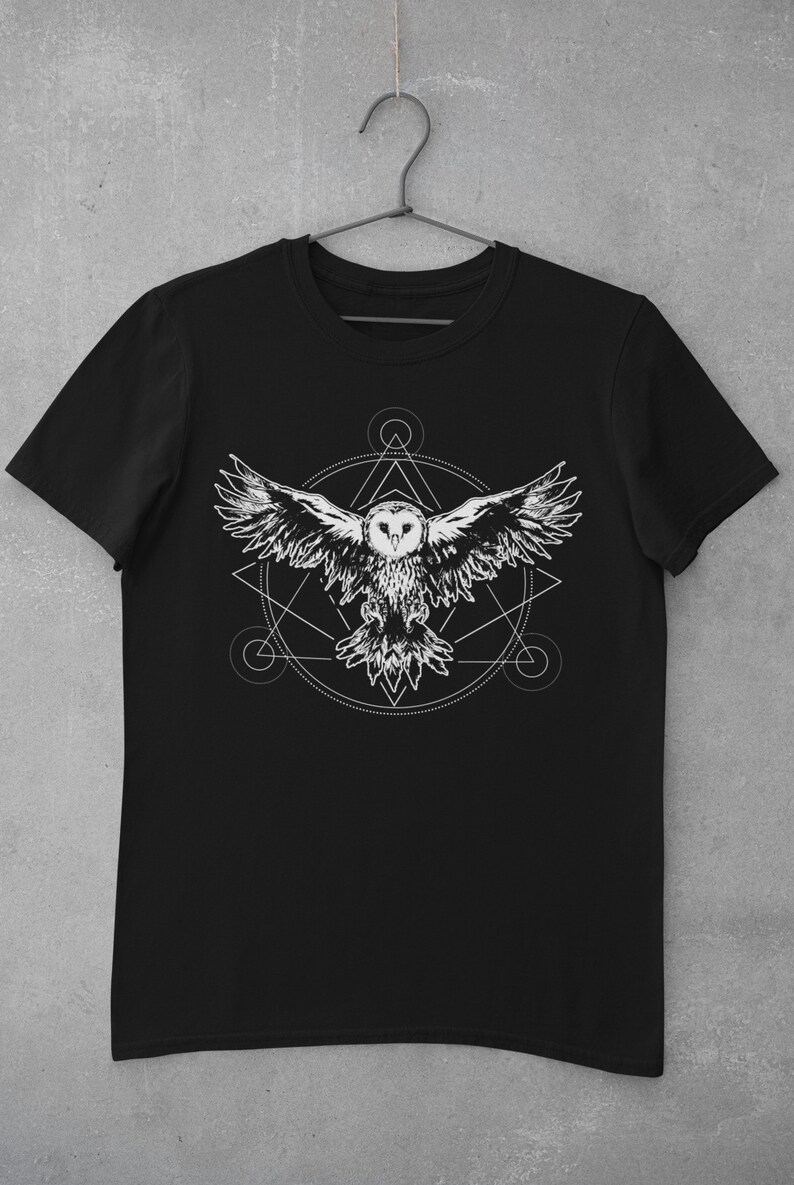 K&ouml;nnte beinhalten: Schwarzes T-Shirt mit einem wei&szlig;en Grafikdruck eines fliegenden Eulen innerhalb eines geometrischen Kreises.