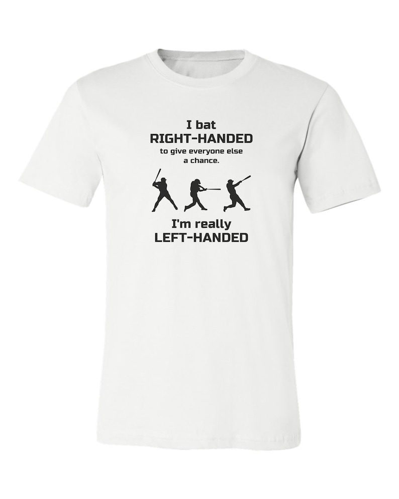 May include: White t-shirt with black text that reads "I bat RIGHT-HANDED to give everyone else a chance. I'm really LEFT-HANDED". The text is accompanied by three black silhouettes of baseball players.