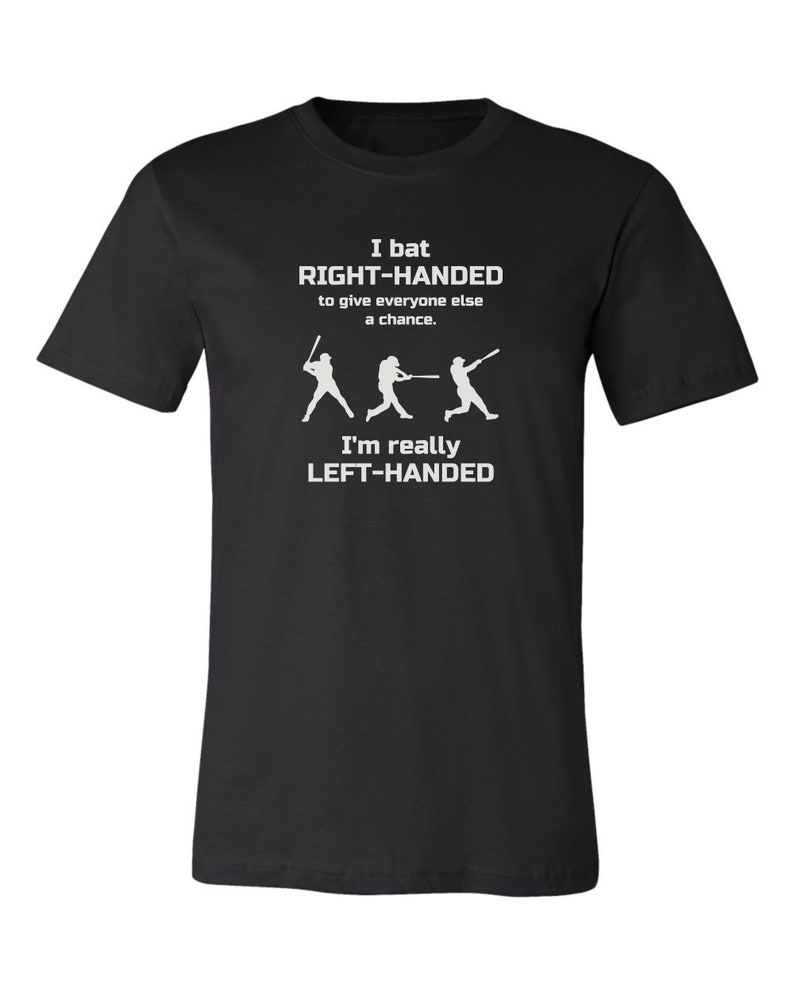 May include: Black t-shirt with white text that reads "I bat RIGHT-HANDED to give everyone else a chance. I'm really LEFT-HANDED". The text is accompanied by three white silhouettes of baseball players batting.