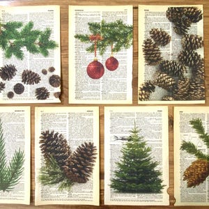 Puede incluir: Seis tarjetas de Navidad imprimibles con varias imágenes de ramas de pino, piñas y adornos. Las tarjetas están impresas en páginas de diccionario vintage.