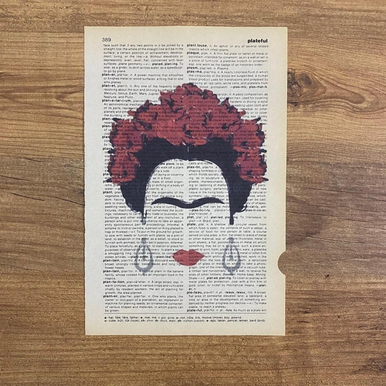 Op de afbeelding: Een digitale kunstprint met een portret van Frida Kahlo met een rode bloemenkrans. Het portret is gesuperponeerd op een vintage woordenboekpagina met het woord "plateful" dat is gemarkeerd.