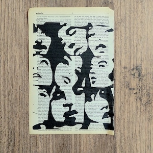 Pu&ograve; includere: Un foglio rettangolare di carta da dizionario color bianco sporco con una audace illustrazione a inchiostro nero di diversi volti umani sovrapposti. Il testo stampato della pagina del dizionario rimane visibile sotto le forme nere dei volti.