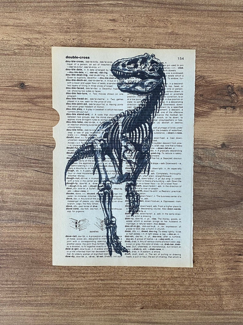 May include: An illustration of a Tyrannosaurus Rex skeleton is printed on a vintage dictionary page. The page has a torn edge and the word "double-cross" is visible.