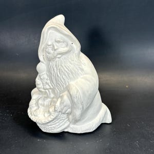 Joli père Noël ancien tenant un casse-noisette et un panier de cadeaux en biscuit en céramique prêt à peindre