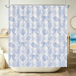May include: A white shower curtain with a repeating pattern of light blue seashells, bows, and diamond shapes. The curtain is hanging in front of a white bathtub, with a wooden shelf and a towel rack visible.