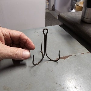 May include: A triple hook fishing lure with a black finish.