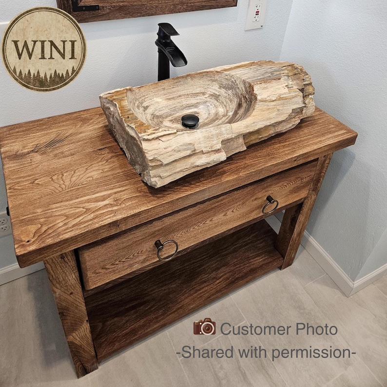A rustic wooden bathroom vanity featuring two drawers with dark metal ring pulls, and an open bottom shelf for storage. The vanity is made of reclaimed wood with a natural finish.
Rustic Bathroom Vanity,  Wood Bathroom Vanity, Custom Single Sink Vanity, Unique Reclaimed Farmhouse Vanity with Storage