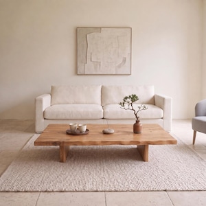 May include: A low rectangular wooden coffee table with a natural live edge, featuring a smooth surface, two sturdy block legs, two small ceramic cups on a round tray, a small stone incense holder, and a miniature bonsai tree in a brown pot.