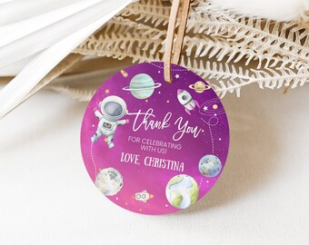 May include: Round purple thank you tag with an astronaut, planets, and stars. The text reads "Thank You" for celebrating with us! Love Christina.