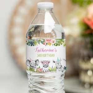 May include: A clear water bottle with a custom label for a 3rd birthday. The label features an elephant, lion, and rhino with party hats and sunglasses, surrounded by floral and leaf accents. Text reads "Katherine's 3rd Birthday."
