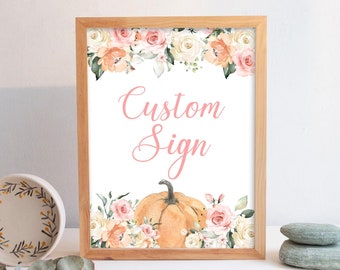 May include: A printable sign with a white background and a pink floral border. The sign says "Custom Sign" in pink text and features a watercolor pumpkin in the center. The sign is perfect for a fall-themed event.