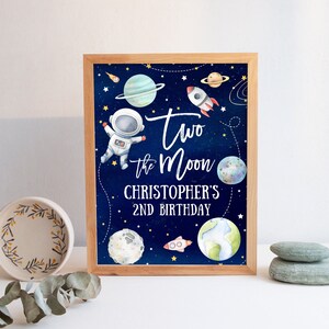 May include: A blue and white printable sign with an astronaut, planets, and stars. The text reads "Two the Moon Christopher's 2nd Birthday".