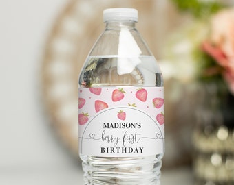 Puede incluir: Etiqueta de botella de agua con un diseño de fresa rosa y blanca. La etiqueta dice "Madison's berry first birthday".