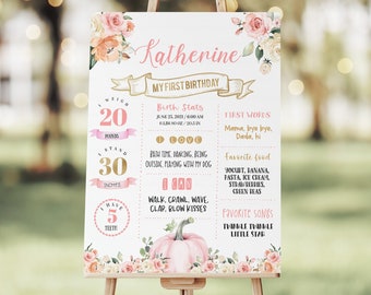 May include: A pink and gold first birthday milestone poster with a pumpkin and floral accents. The poster includes the name Katherine, birth stats, first words, favorite foods, and favorite songs.
