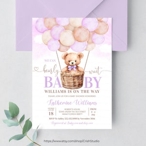 May include: A baby shower invitation featuring a watercolour illustration of a teddy bear in a basket, floating in a hot air balloon made of purple and beige balloons. The text reads "We can bearly wait Baby Williams is on the way".
