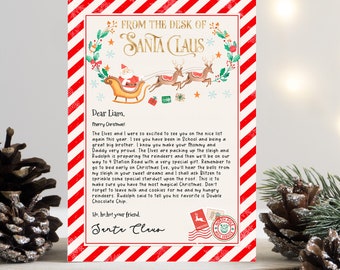 May include: A red and white striped card with a festive Christmas scene of Santa Claus in his sleigh with reindeer. The card is addressed to Liam and includes a personalised message from Santa Claus. The text reads "From the Desk of Santa Claus" and "Dear Liam, Merry Christmas!"